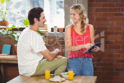 Businesswoman pointing towards digital table while looking at co