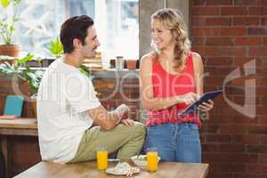 Businesswoman pointing towards digital table while looking at co