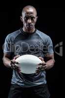 Portrait of serious sportsman holding rugby ball