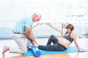 Male instructor massaging foot of pregnant woman