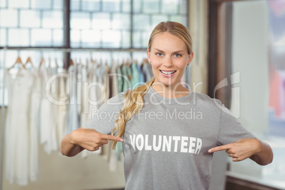 Portrait of happy woman showing volunteer text on tshirt