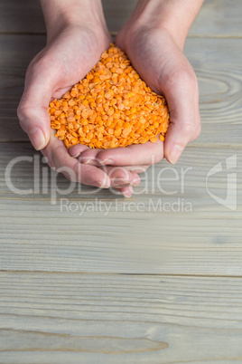 Woman showing handful of red lentils