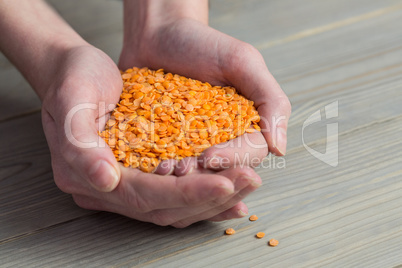 Woman showing handful of red lentils