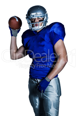 Portrait of American football player in uniform throwing ball