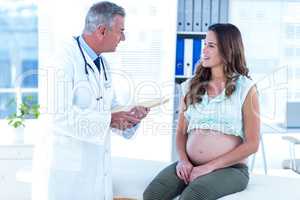 Male doctor in conversation with pregnant woman in hospital