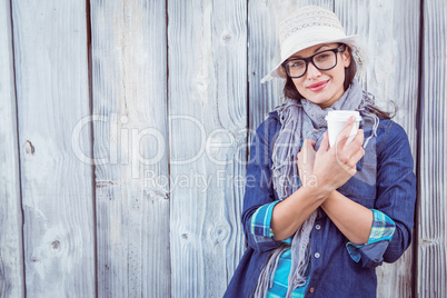 Happy hipster holding a cup in her hand