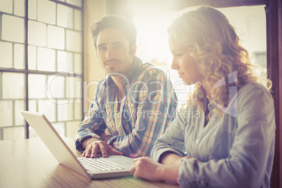 Colleagues discussing while sitting in office