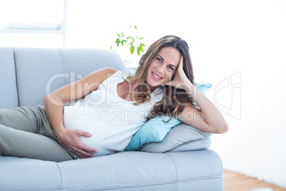 Smiling pregnant woman relaxing on sofa