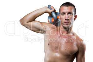 Confident male crossfitter holding kettlebell
