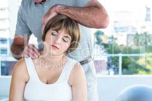 Therapist holding head of pregnant woman while massaging