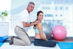 Gym trainer massaging happy pregnant woman
