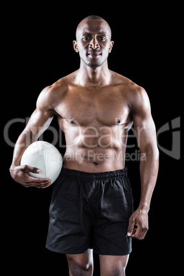 Portrait of shirtless sportsman holding rugby ball