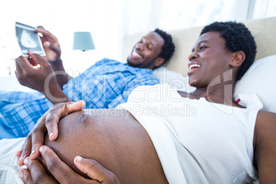 Pregnant woman touch her belly while looking