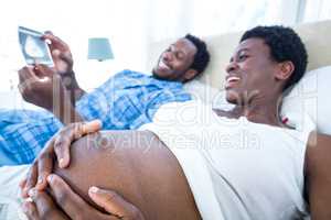 Pregnant woman touch her belly while looking