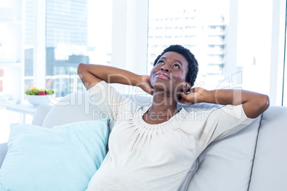Woman looking up while relaxing on sofa at home