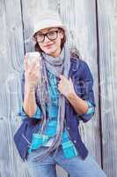 Happy hipster holding a cup in her hand
