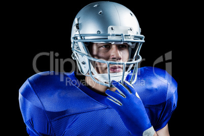 Confident sportsman holding helmet while looking away