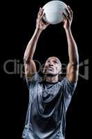 Sportsman looking up while catching rugby ball