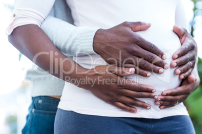 Mid section of man along with woman touching belly