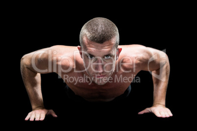 Confident shirtless athlete doing push ups