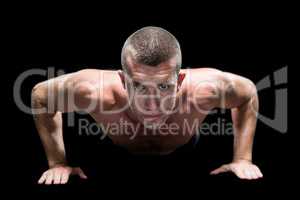 Confident shirtless athlete doing push ups