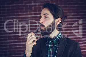 Fashionable man smoking pipe