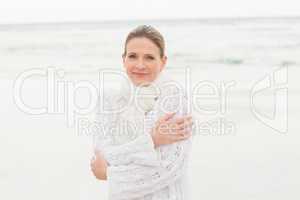 Woman standing at shore with arms crossed