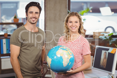 Cheerful business people holding  globe