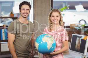 Cheerful business people holding  globe