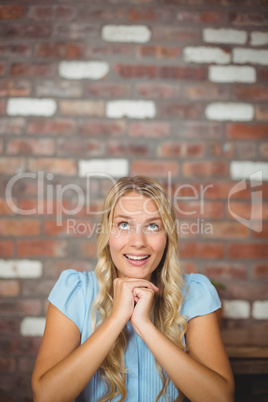 Smiling woman with hand on chin sitting in office