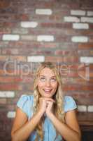 Smiling woman with hand on chin sitting in office