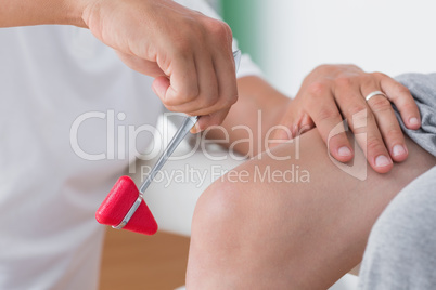 Doctor checking reflexes of the knee of his patient