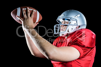 Side view of American football player throwing ball