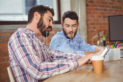 Young businessman looking towards digital tablet