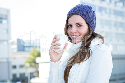 Cold brunette in warm clothes drinking coffee