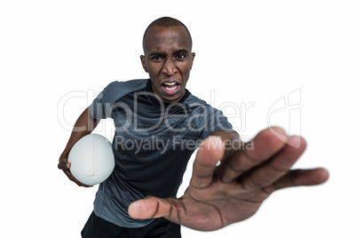 Portrait of sportsman with rugby ball gesturing while defending