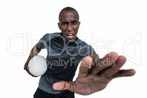 Portrait of sportsman with rugby ball gesturing while defending