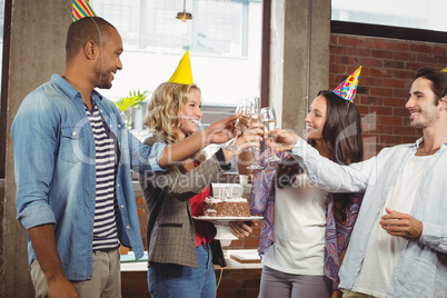 Happy colleagues toasting with champagne in office