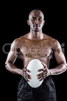 Portrait of shirtless athlete holding rugby ball