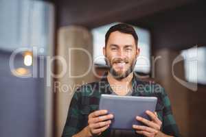 Portrait of cheerful businessman holding digital tablet