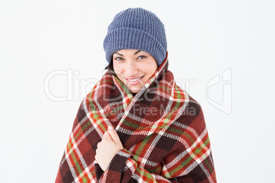 Smiling brunette with checked blanket