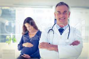 Portrait of male doctor with pregnant woman at clinic