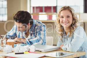 Portrait of woman with colleague working