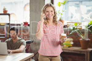 Portrait of businesswoman talking over phone in office