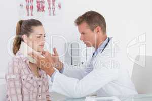 Doctor examining patient wearing neck brace