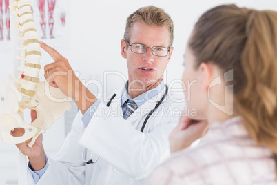 Doctor explaining anatomical spine to his patient Doctor explaining anatomical spine to his patient