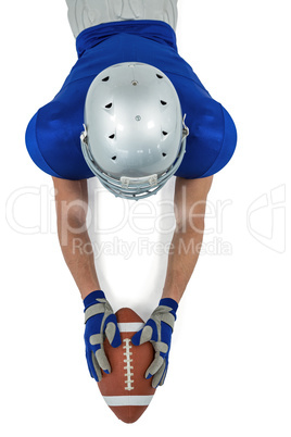 High angle view of American football player reaching towards bal