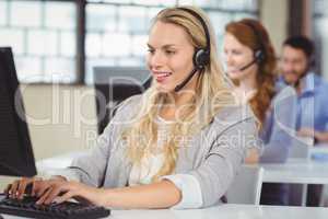 Woman speaking over headset while working