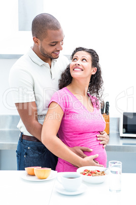 Happy couple standing in kitchen