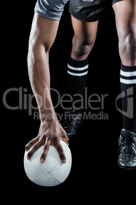 Low section of athlete holding rugby ball Low section of athlete holding rugby ball